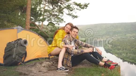 可爱的夫妇坐在山顶上在阳光明媚的夏天欣赏大自然的景色视频的预览图