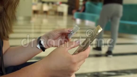 女人用电话和信用卡在酒店房间里买东西视频的预览图