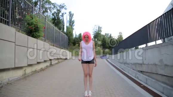 stadicam拍摄的混合种族时尚时髦时髦少女走路吹着带粉色假发的红色气球视频的预览图