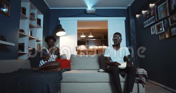 年轻的休闲黑人夫妇分别坐在沙发上看电影在打架和争吵后不说话慢动作视频的预览图