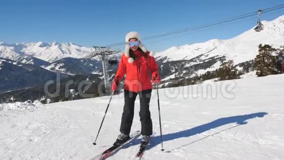 一个穿着红色滑雪服的女人在山坡上侧身爬山视频的预览图