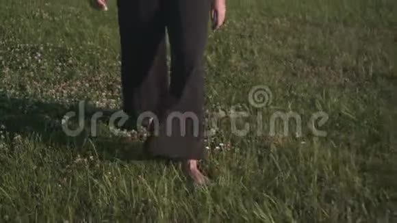 商业女性穿着黑色裤子和白色外套微笑笑着光着脚在草坪上玩自由视频的预览图