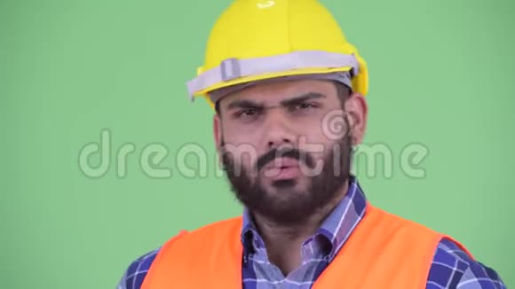 一脸严肃年轻超重留胡子的印度建筑工人点头无礼视频的预览图