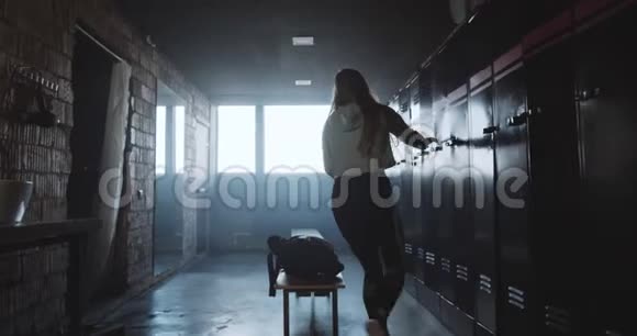 美丽的年轻快乐的高加索女人在黑暗的更衣室健身房锻炼后换衣服生活动机的概念视频的预览图