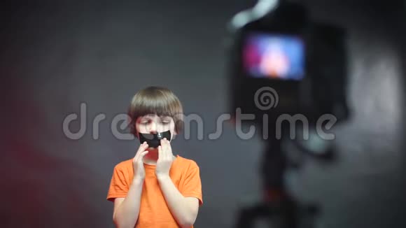 一个带着黑胶带的孩子坐在摄像机前视频的预览图