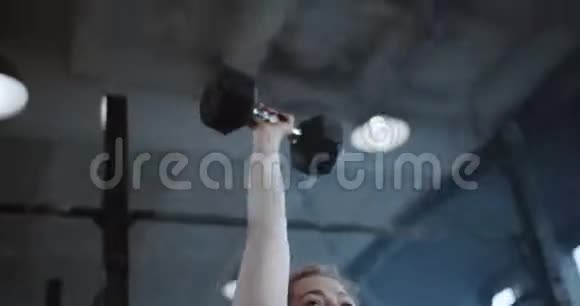 特写年轻快乐美丽的白种人红头发的女运动员在大型职业健身房举起沉重的哑铃视频的预览图