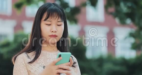 亚洲女孩在户外社交网络聊天视频的预览图