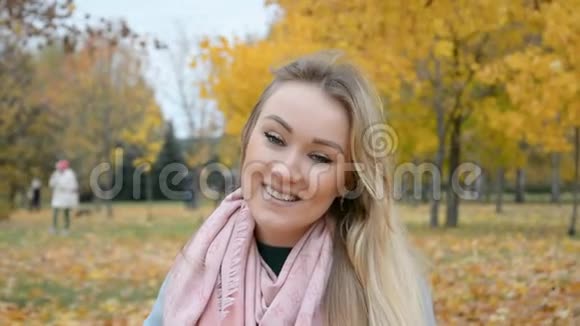 秋天的户外肖像一位美丽的金发女郎微笑着看着相机视频的预览图