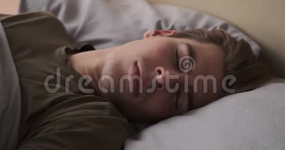 头痛的男人在家里的床上醒来视频的预览图
