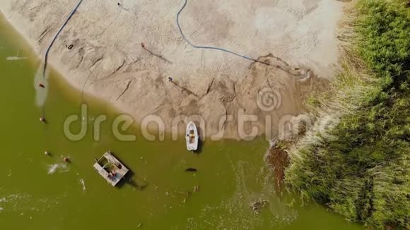 空中无人机景观自定义挖泥船泵冲洗沙子和加深航道在沙质淤泥岛海岸的河流或视频的预览图