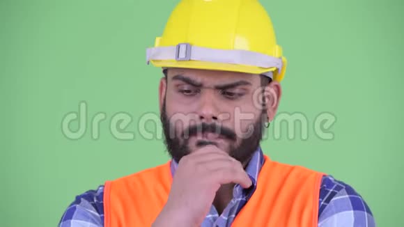 面对压力年轻超重留着胡子的印度男子建筑工人思考和俯视视频的预览图