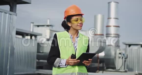 建筑工地上一位颇具魅力的非洲裔年轻女商人手里拿着平板电脑和定量配给视频的预览图