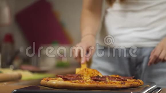 女厨师用木抹子将新鲜准备好的辣香肠比萨饼和奶酪放在烤盘上顶部视图视频的预览图