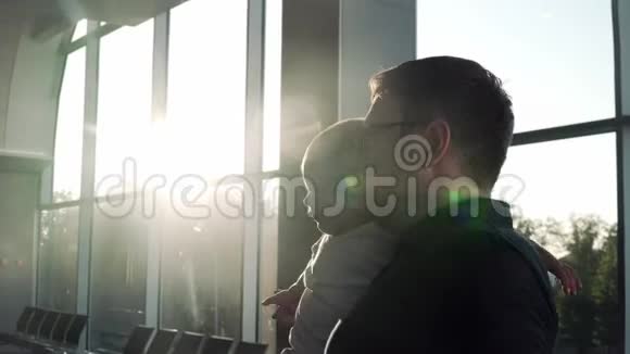 在机场的爸爸和宝宝日落时有太阳耀斑爱情关系视频的预览图