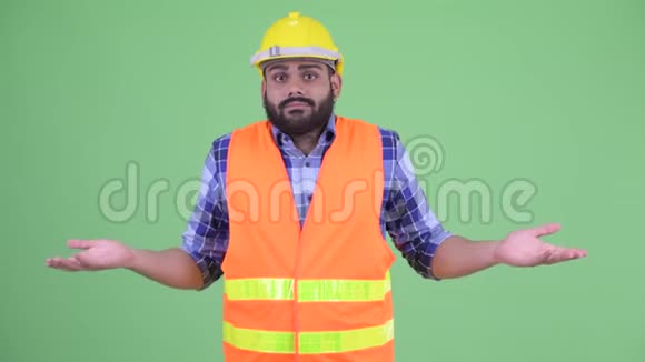 困惑的年轻超重胡须印度男子建筑工人耸肩视频的预览图