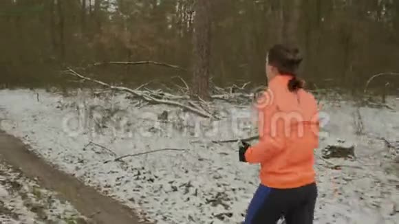 女性在户外做有氧运动有动力的女人在冬季公园慢跑作为减肥的日常锻炼一路跑积极主动视频的预览图