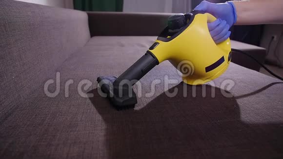 家具和公寓清洁概念在家用蒸汽清洁器打扫沙发的男人视频的预览图