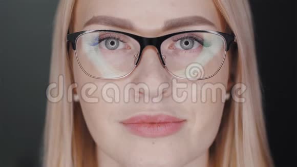 戴着眼镜的漂亮金发商务女性看着镜头微笑着露出戴着黑色牙套的牙齿视频的预览图