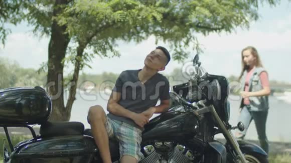 年轻人骑着摩托车在公园里休闲视频的预览图