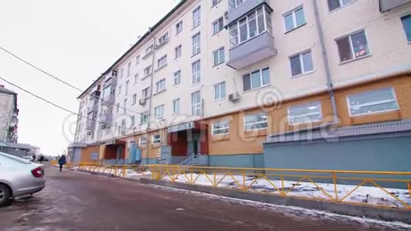 冬季街道上有明亮立面的住宅建筑视频的预览图