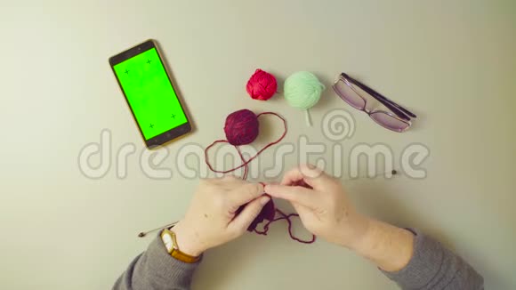 绿色屏幕老妇人的手在编织羊毛视频的预览图