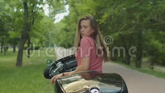 坐在摩托车上的迷人女孩的肖像视频的预览图