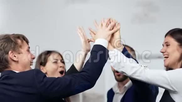 一队商业人士为胜利者做手势一起拍手并表现出积极的情绪视频的预览图