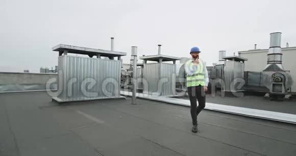年轻的建筑工人戴着安全帽留着胡子在工地的屋顶上跳舞非常兴奋视频的预览图
