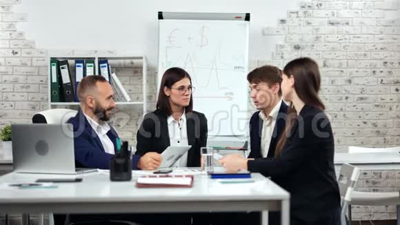青年员工小组与轻办公室内男老板讨论工作方案视频的预览图