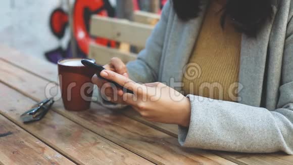 年轻的商务女性在工作时使用智能手机在手机上键入短信特写视频的预览图