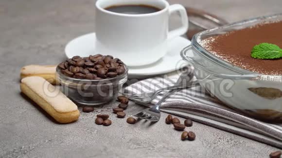 玻璃烤盘中的提拉米苏甜点和一杯新鲜的热浓缩咖啡在混凝土背景下视频的预览图