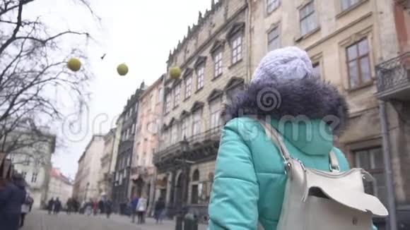 一个背着背包的女孩走在城市狭窄的老街上有着美丽的建筑旅行慢动作视频的预览图