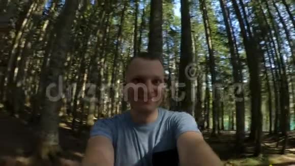 一个快乐的白种人在自然界的一个古老的森林里旋转动作缓慢Snricam效应视频的预览图
