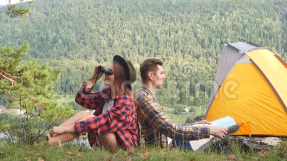 可爱的夫妇坐在山顶上在阳光明媚的夏天欣赏大自然的景色视频的预览图