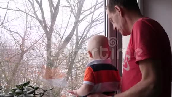 祖父和孙子看着窗外慢动作视频视频的预览图
