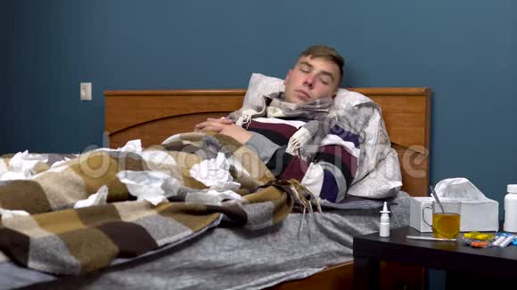 一个年轻人在鼻子里喷药那家伙躺在床上脖子上戴着围巾病得很重视频的预览图
