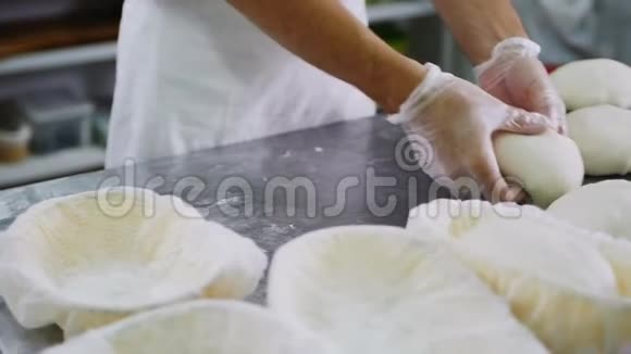 年轻厨师揉搓面团放入烤盘中视频的预览图