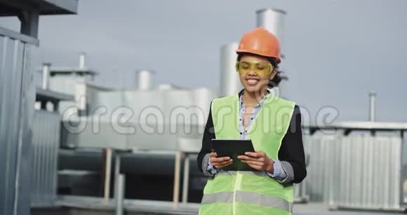 有魅力的非洲女青年工程师在建筑工地上直视镜头微笑着捧着一个视频的预览图