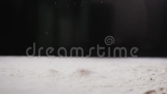 将面粉倒入黑色模糊背景特写的桌子上视频的预览图