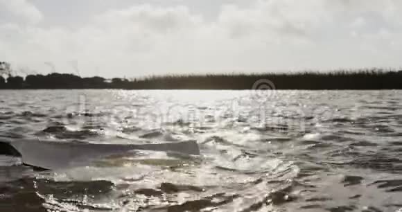 在湖上使用桨的近景视频的预览图