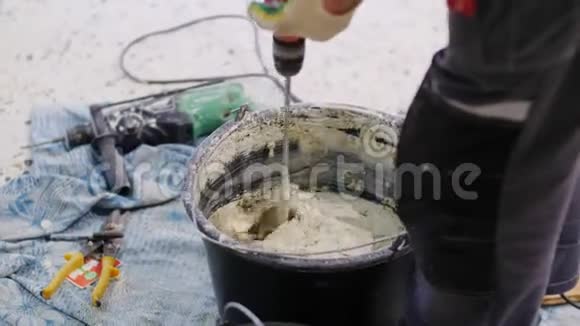员工在施工特写镜头前用桶准备湿混视频的预览图