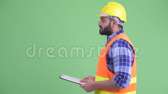 超重留胡子的印度男子建筑工人手持剪贴板说话的轮廓图视频的预览图