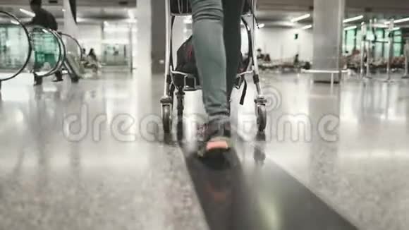 女士携带行李车在机场候机楼步行视频的预览图