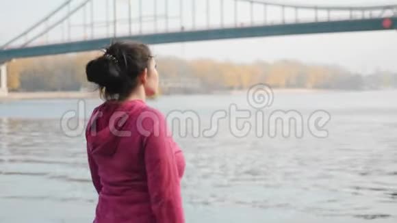 跟随身材丰满的女性训练穿着黑色和紫色运动服的北欧步行杆视频的预览图