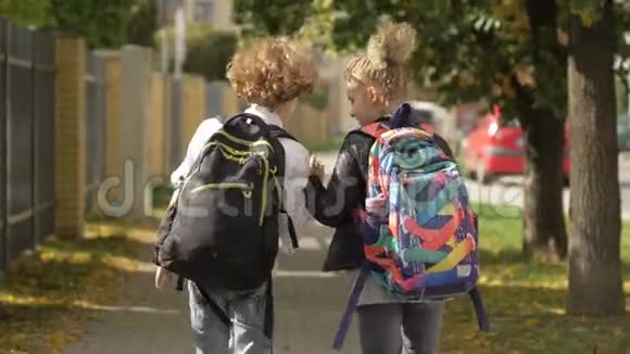 两个女孩和男孩在城市街道上走过汽车妹妹和她的哥哥回学校携带儿童视频的预览图