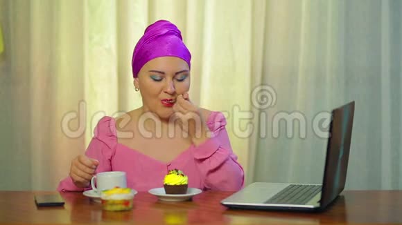 戴着头饰在咖啡馆里的已婚犹太人喝咖啡吃糕点在电脑前工作视频的预览图