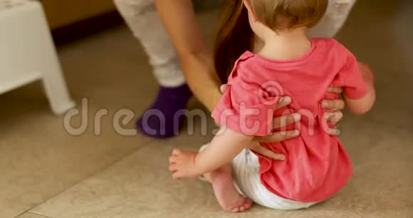 女人从地板上接孩子视频的预览图