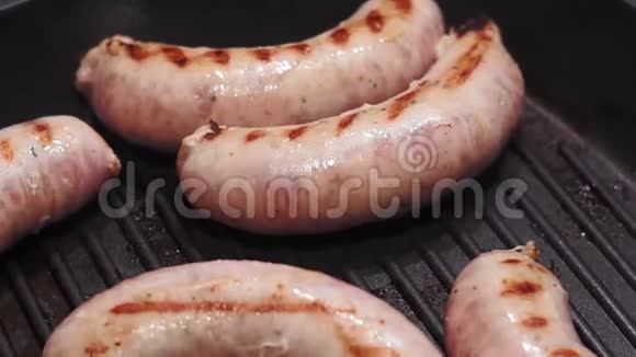 美味的烤猪肉香肠卷在热烤盘上在平底锅上炸香肠视频的预览图