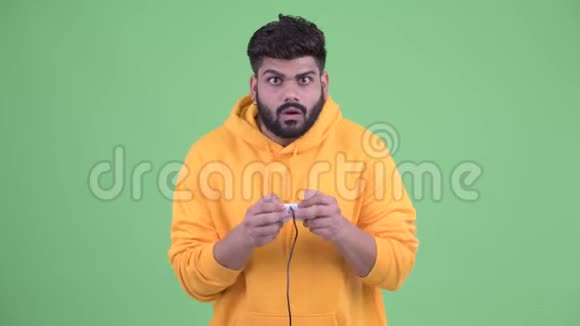 快乐年轻体重超重留着胡子的印度男人在玩游戏赢得胜利视频的预览图