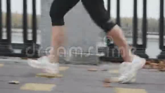 训练女足在城市长廊上沿着河流快速奔跑黑色运动腿的女人每天在户外跑步视频的预览图